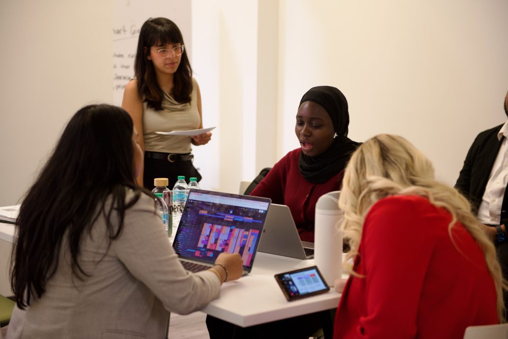 UNC Charlotte students work as a group with a mentor to prepare a pitch during CO-LAB's grand opening.